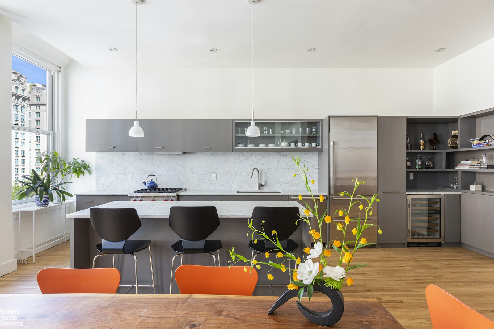 a kitchen with a table chairs and a potted plant