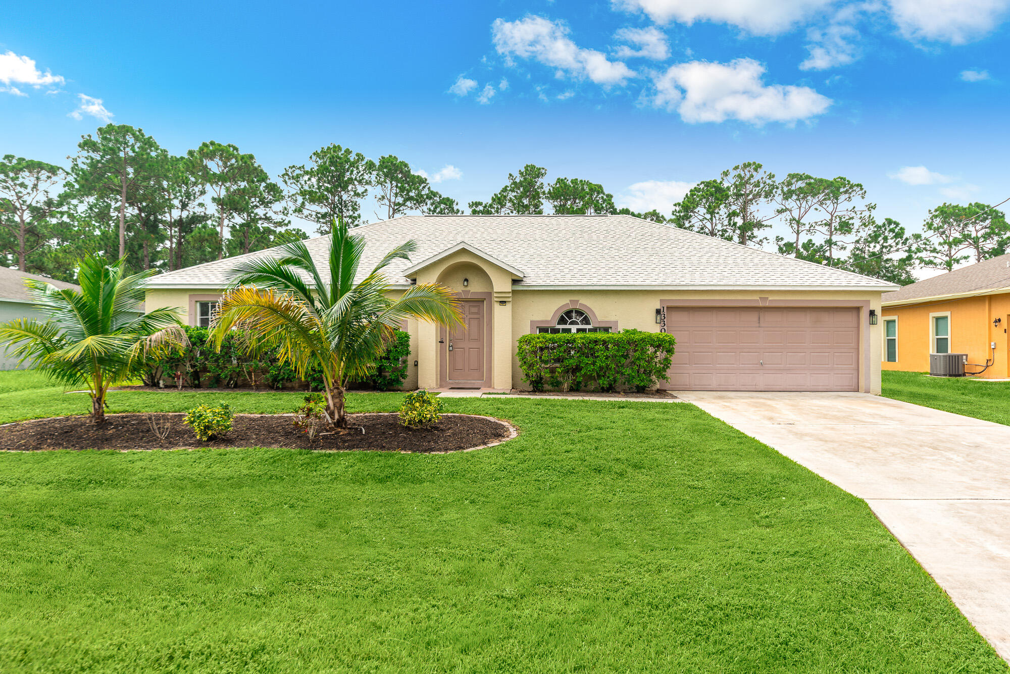 a front view of a house with a yard and garage