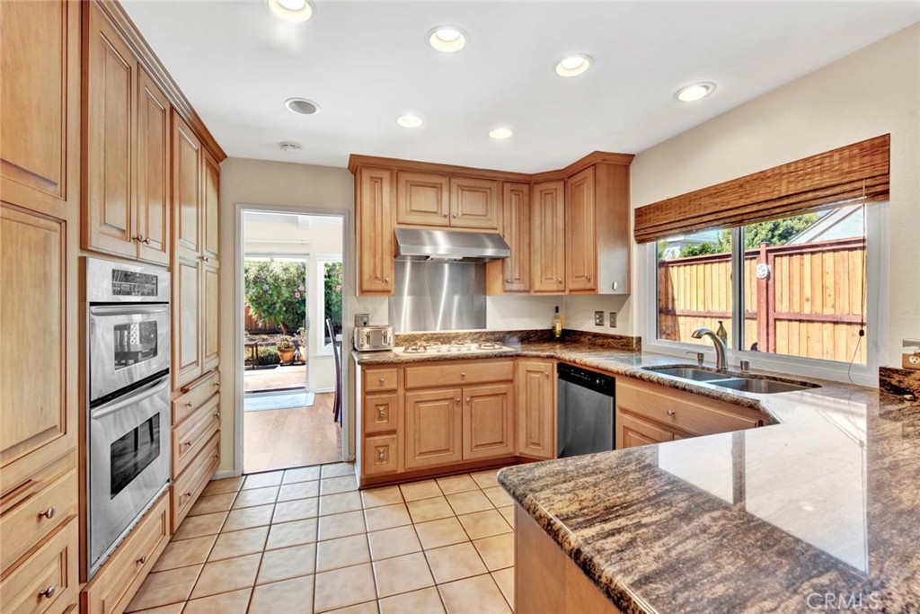 a kitchen with stainless steel appliances granite countertop a stove a sink and a refrigerator