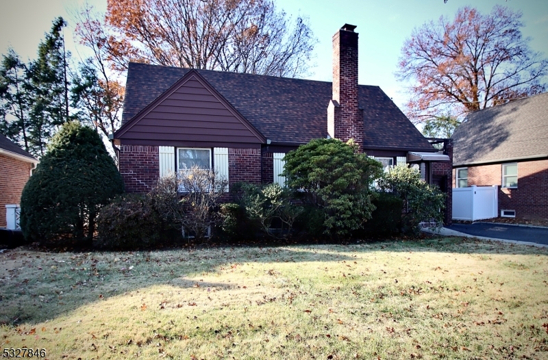 a view of a house with a yard and wooden fence