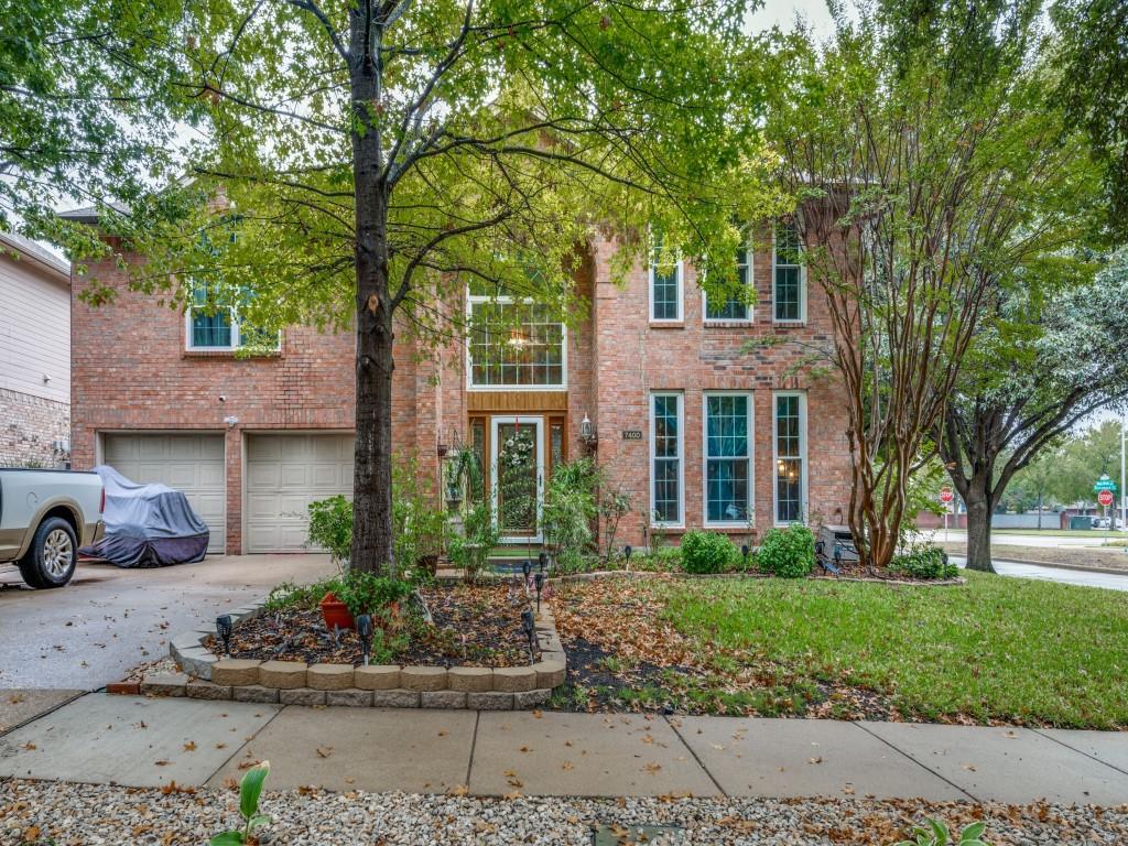 front view of a brick house with a yard