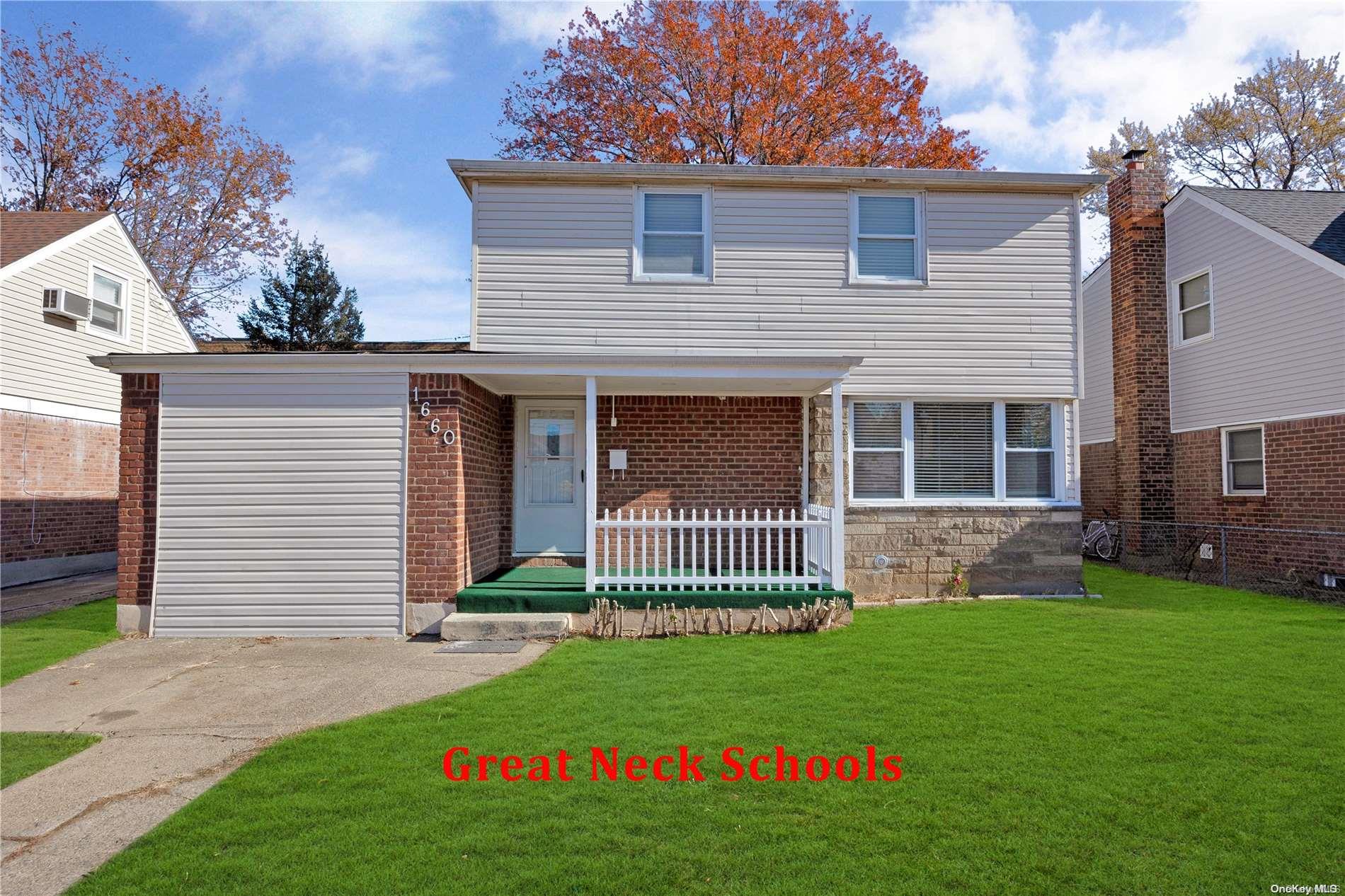 a front view of a house with a garden and yard