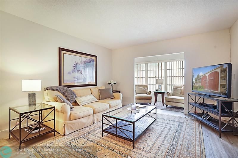 a living room with furniture a flat screen tv and a window