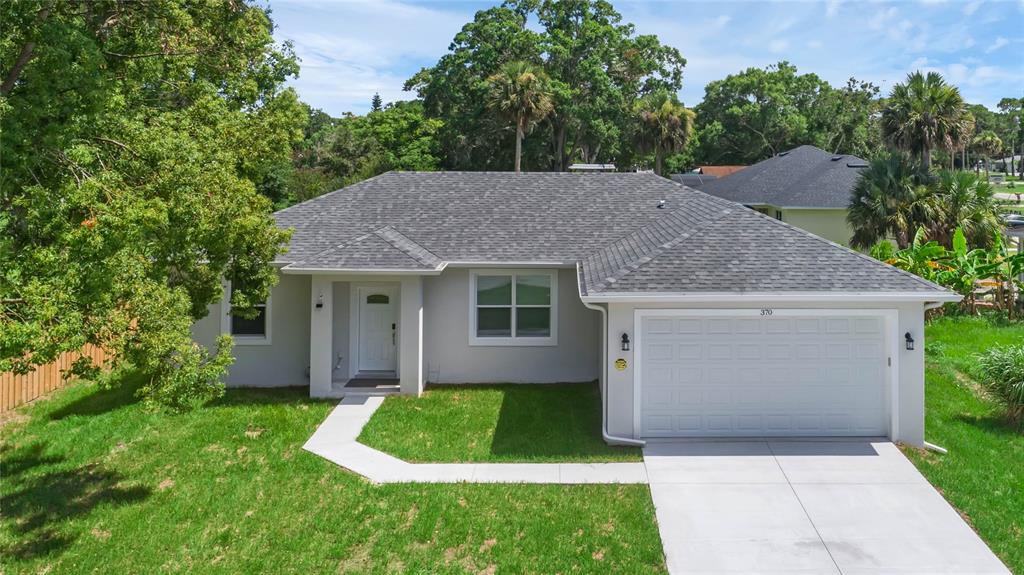 a aerial view of a house with a yard and large tree