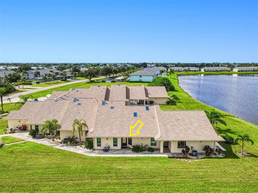 an aerial view of a house with a garden and lake view