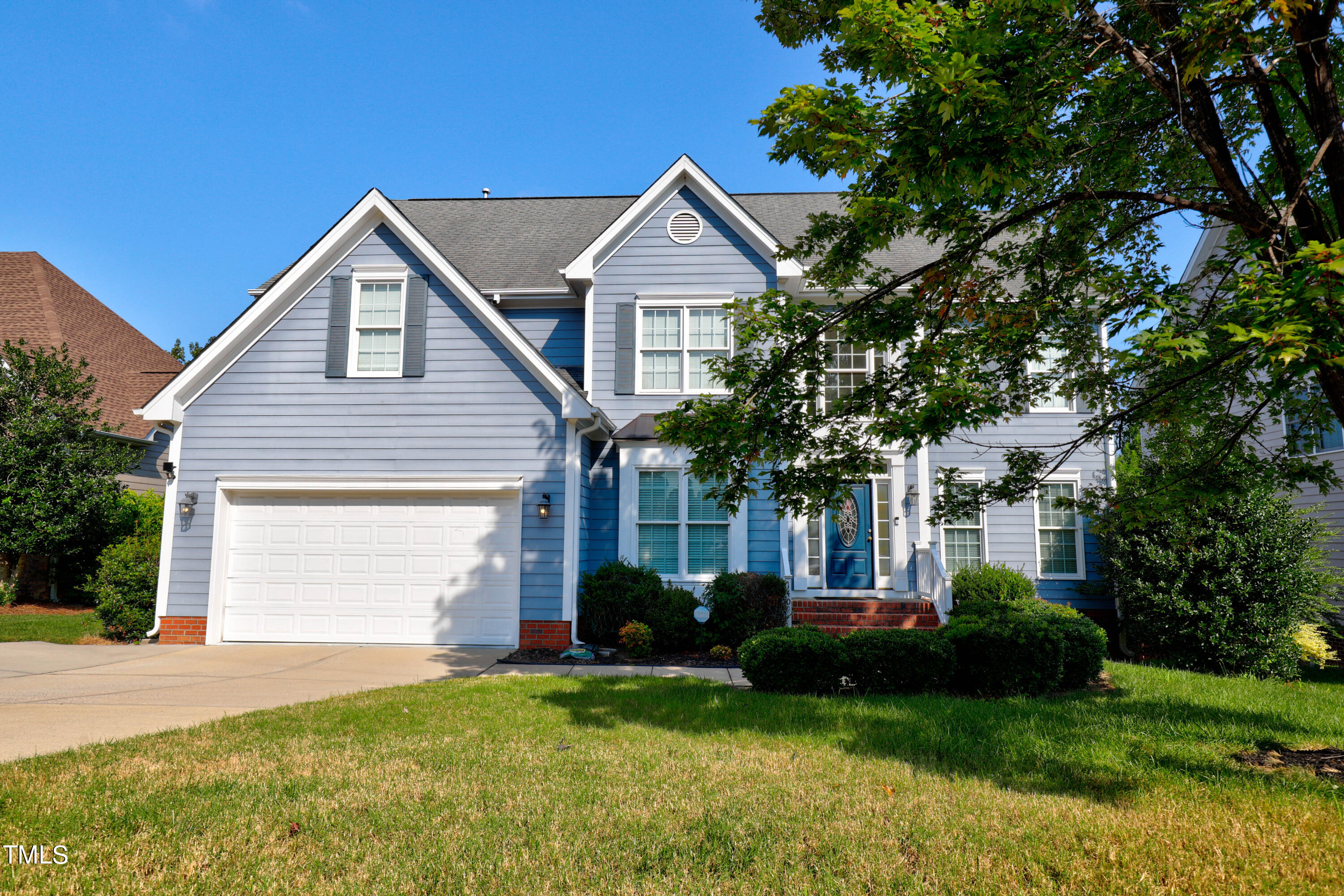 a front view of a house with a garden and yard