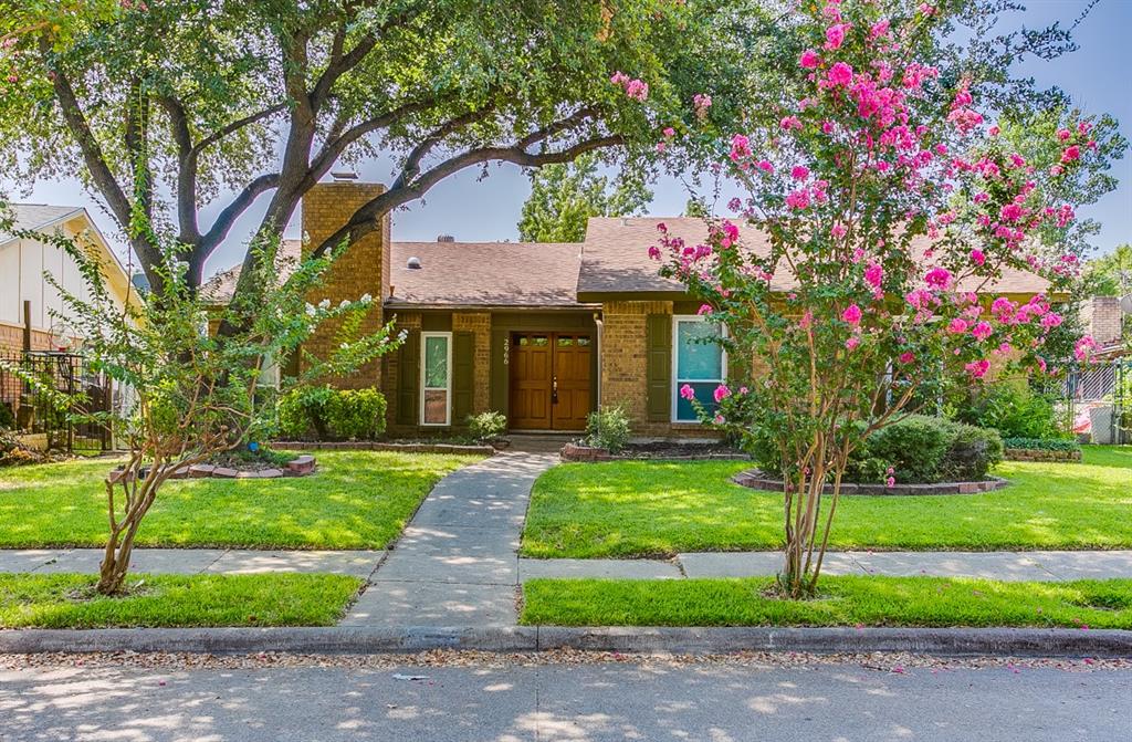 a front view of a house with yard and green space