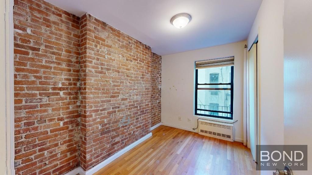 a bathroom with a wooden floor and a window