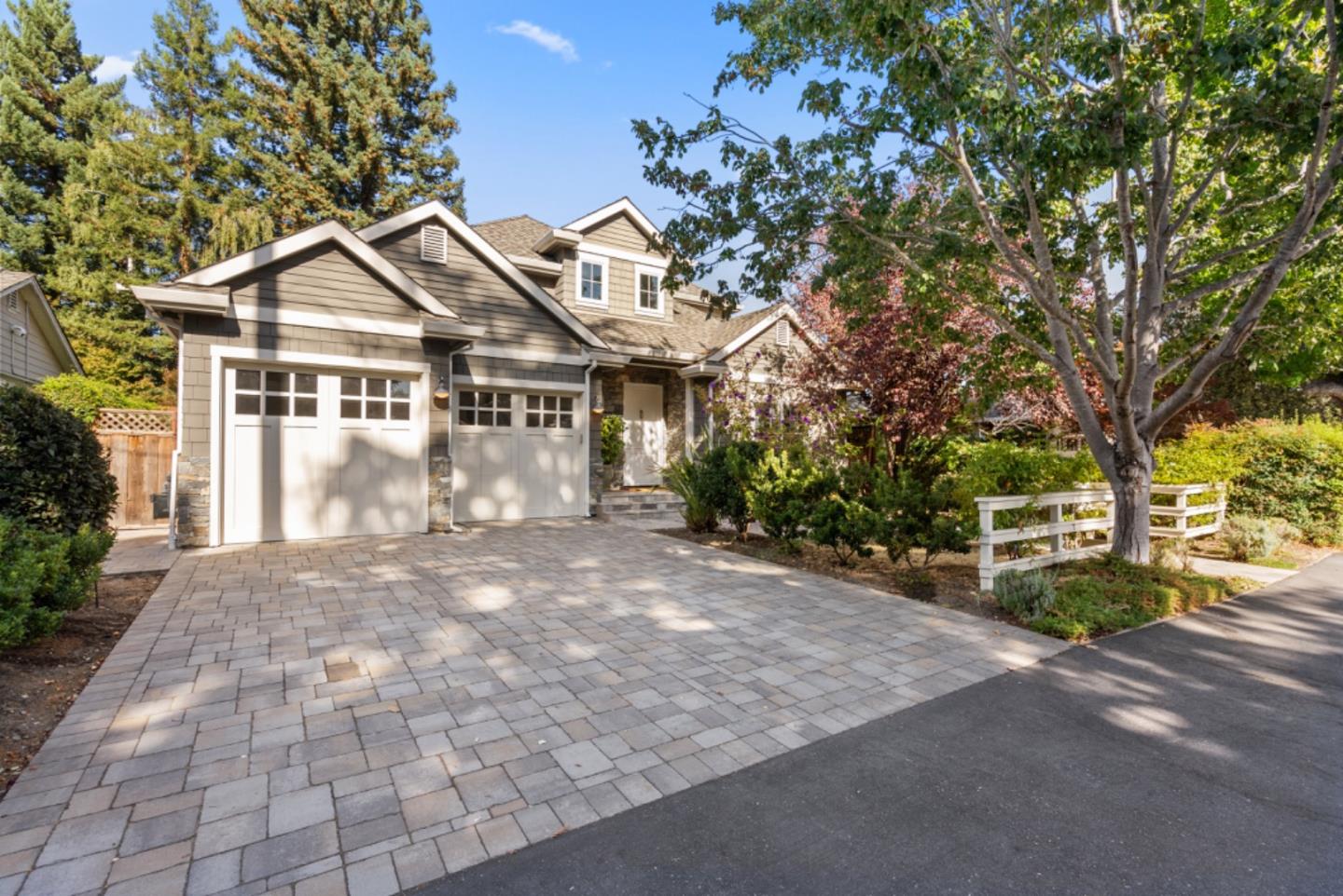 a front view of a house with a garden and trees