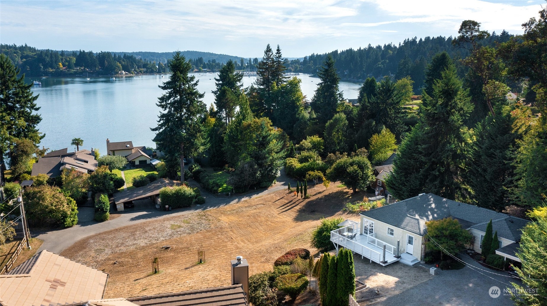 an aerial view of a house with outdoor space and lake view in back