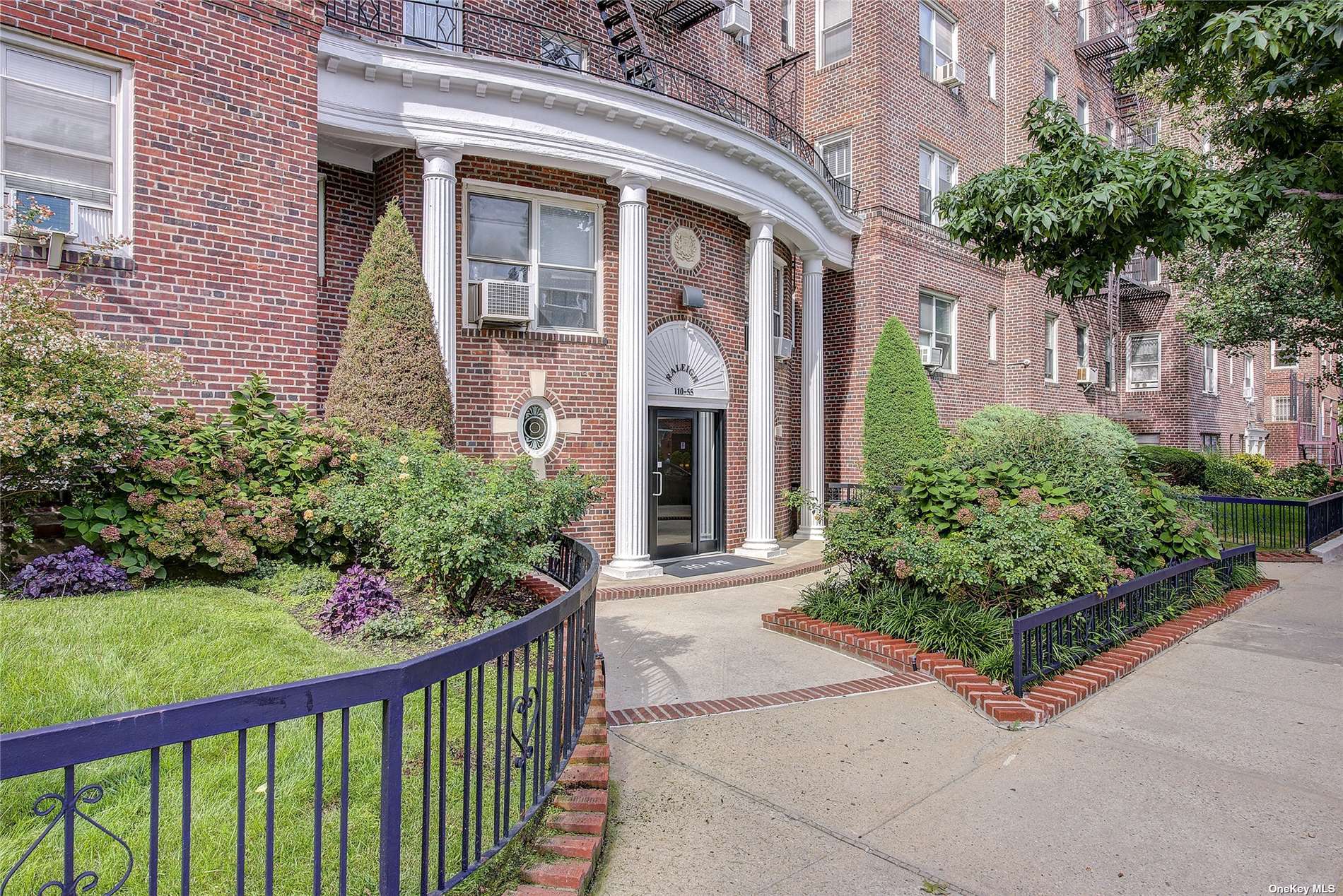 a front view of a house with a yard and potted plants