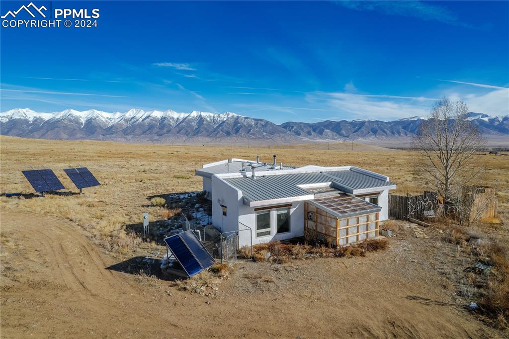 Back of house featuring a mountain view and an outbuilding