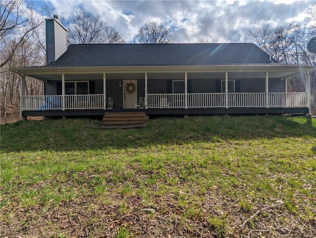 Farmhouse-style home with a porch and a front lawn