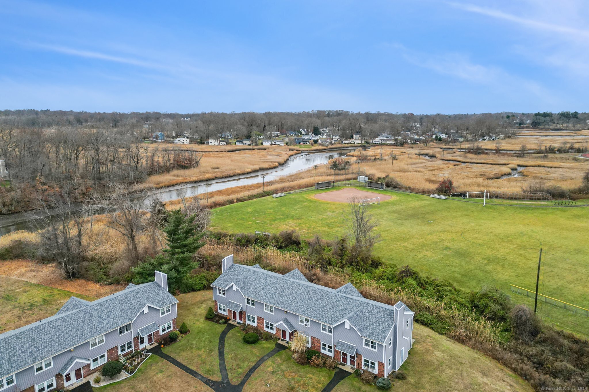 an aerial view of a house with a garden and lake view