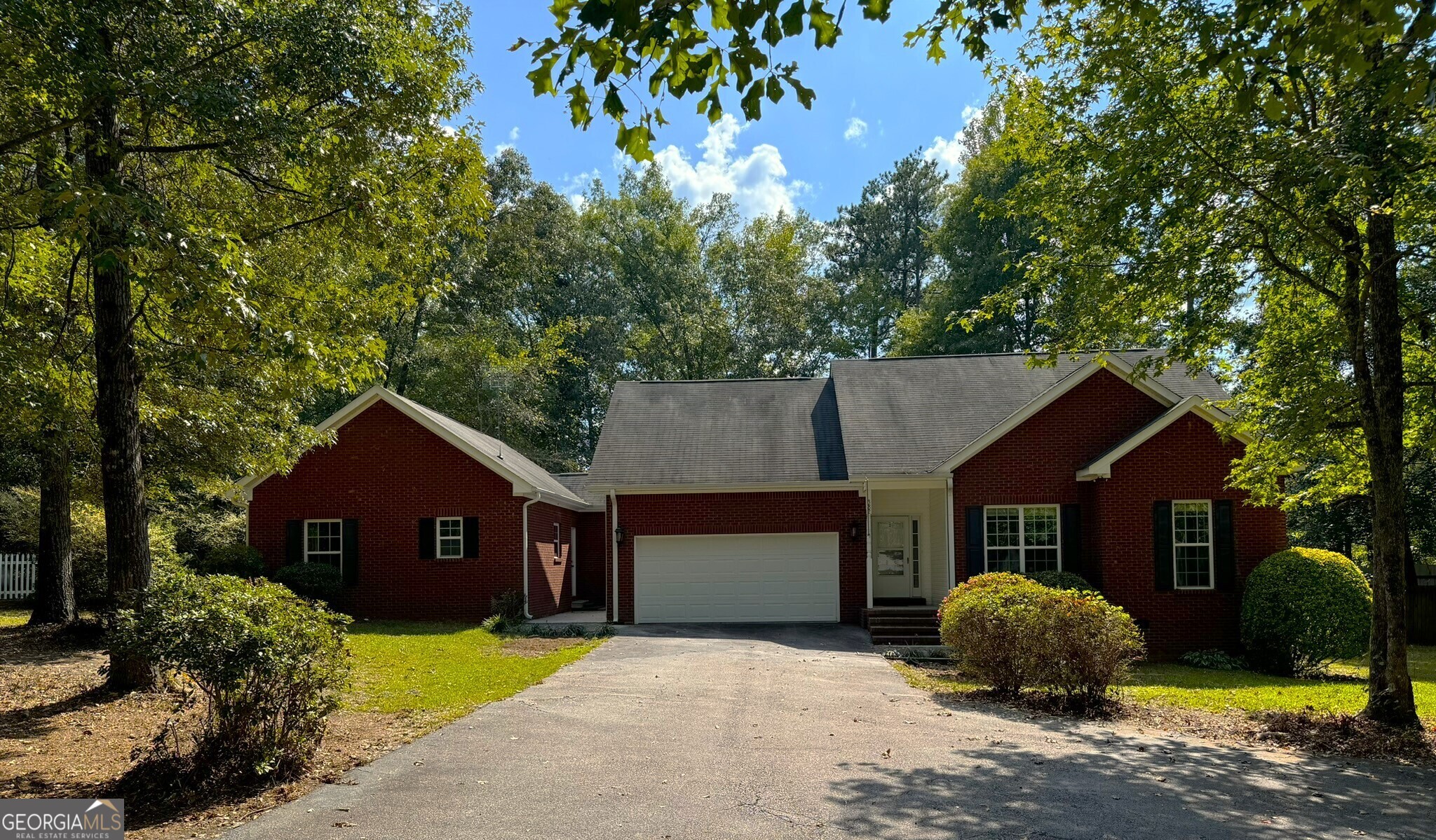 a front view of a house with a garden and tree