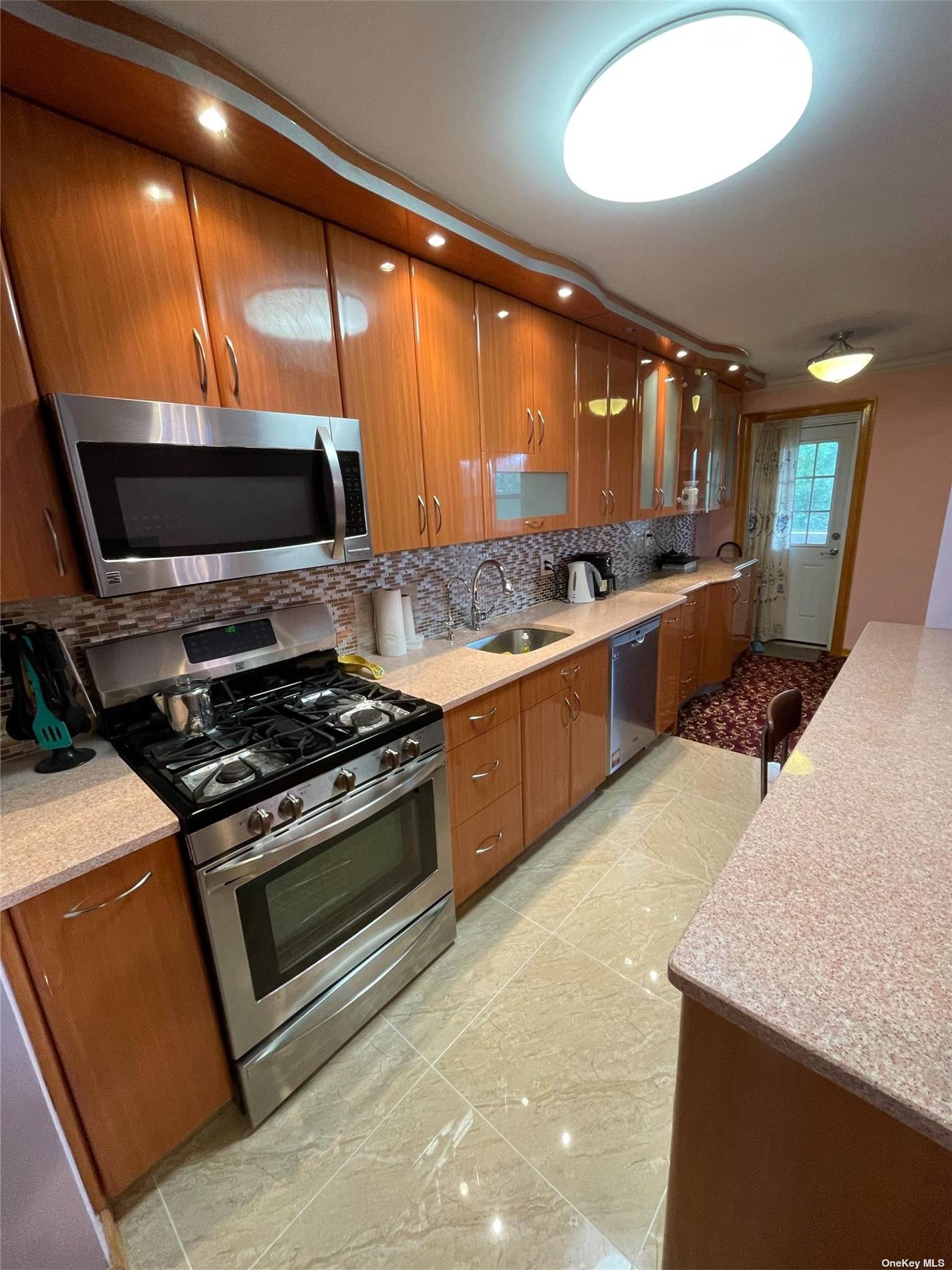 a large kitchen with stainless steel appliances granite countertop a stove and a sink