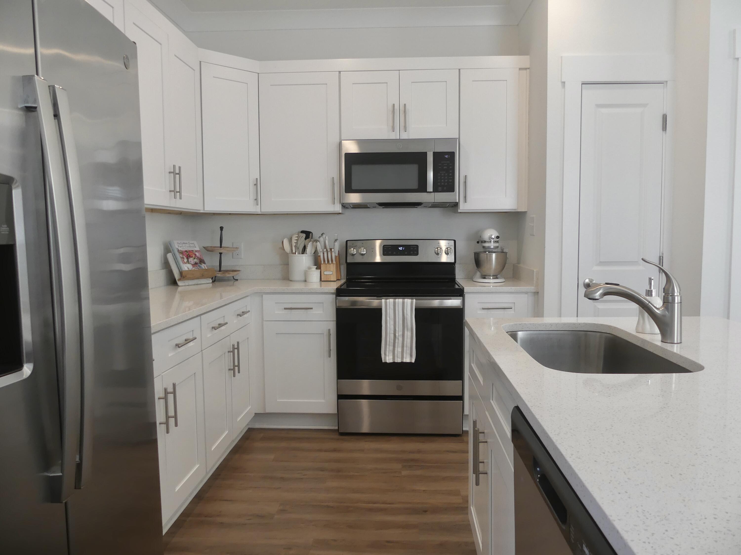 a kitchen with white cabinets sink and stainless steel appliances