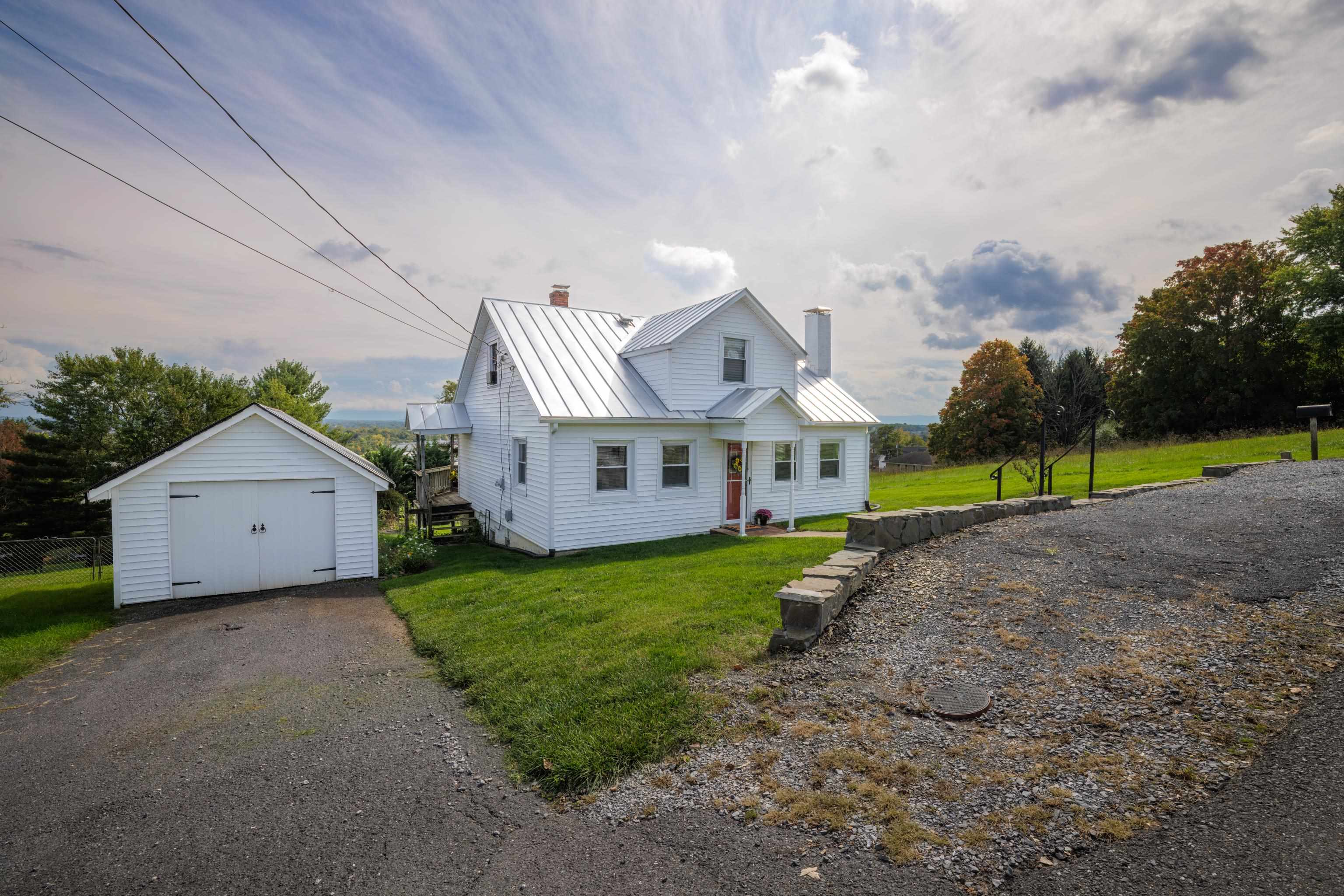 a view of a house with a yard and fence