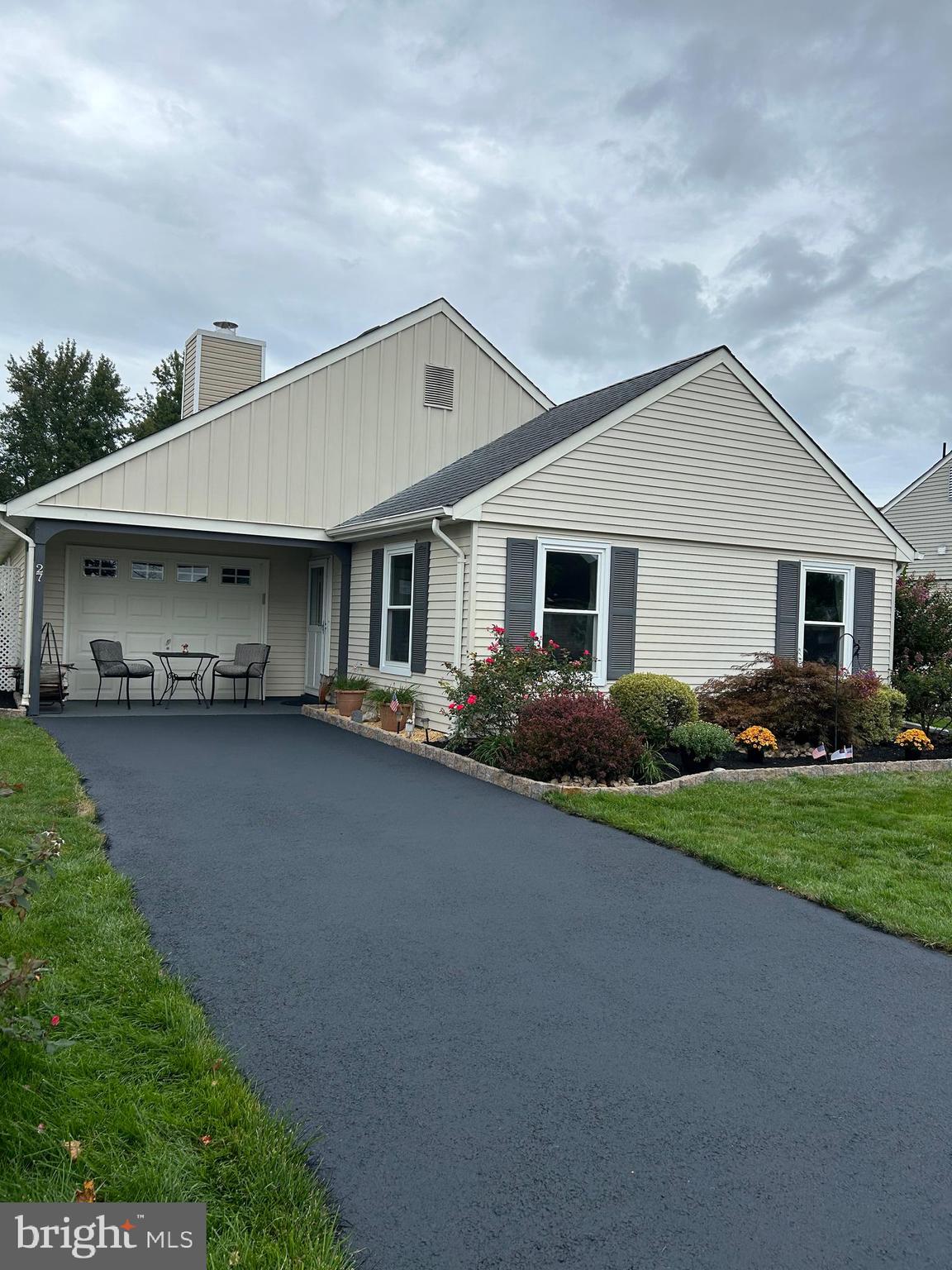 a front view of a house with a garden and yard