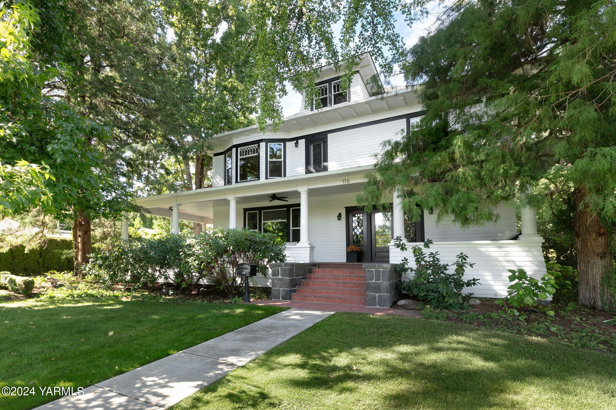 a front view of a house with a garden and plants