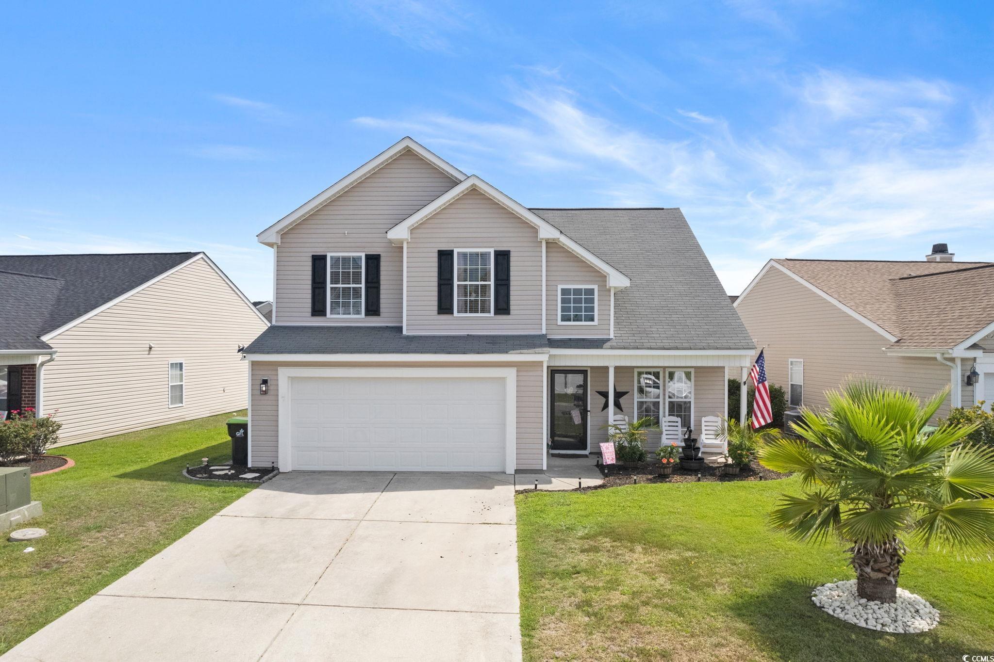 Front facade featuring a garage and a front yard