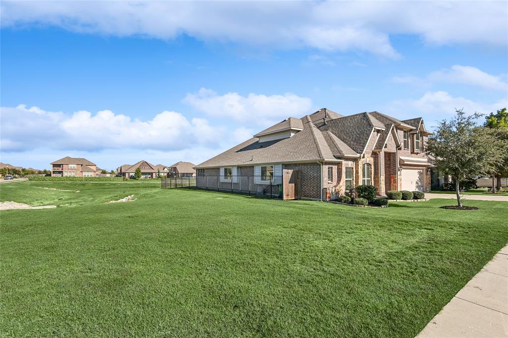 a view of a big house with a big yard and large trees