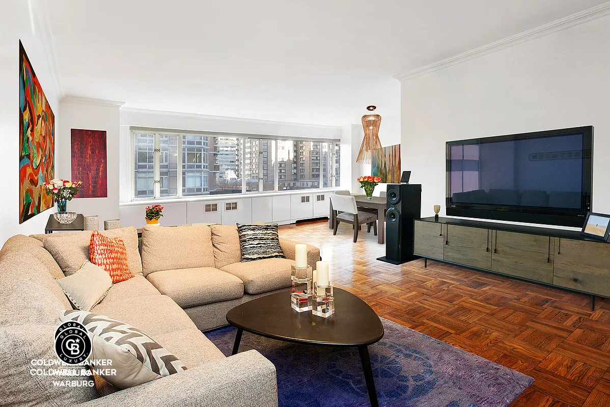 a living room with furniture a large window and a flat screen tv