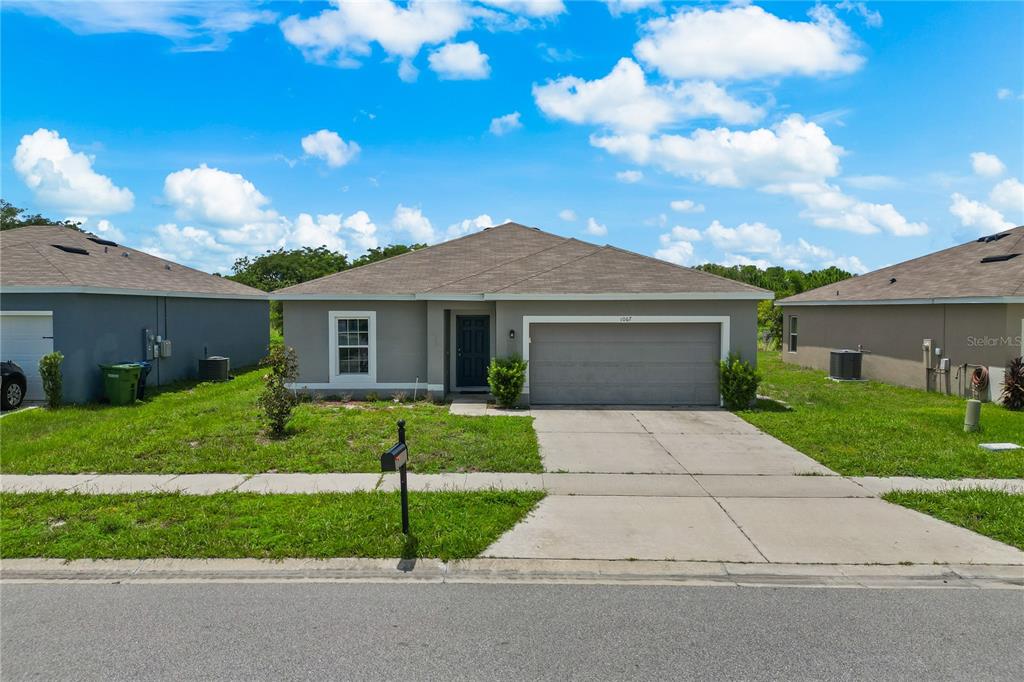 a front view of a house with a garden and yard