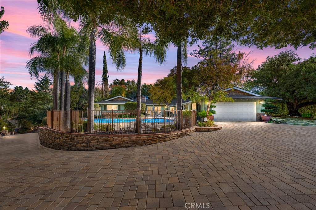 a view of a house with a yard and palm trees