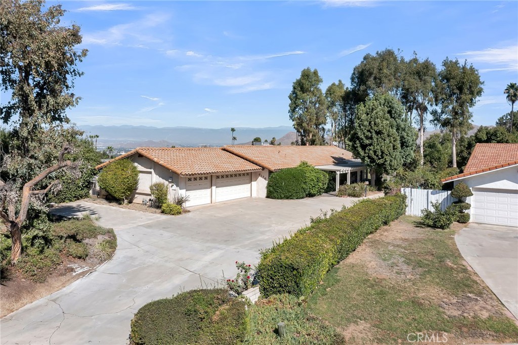 an aerial view of a house with a yard and mountain view in back