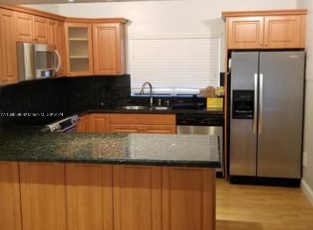 a kitchen with stainless steel appliances granite countertop a refrigerator and a stove