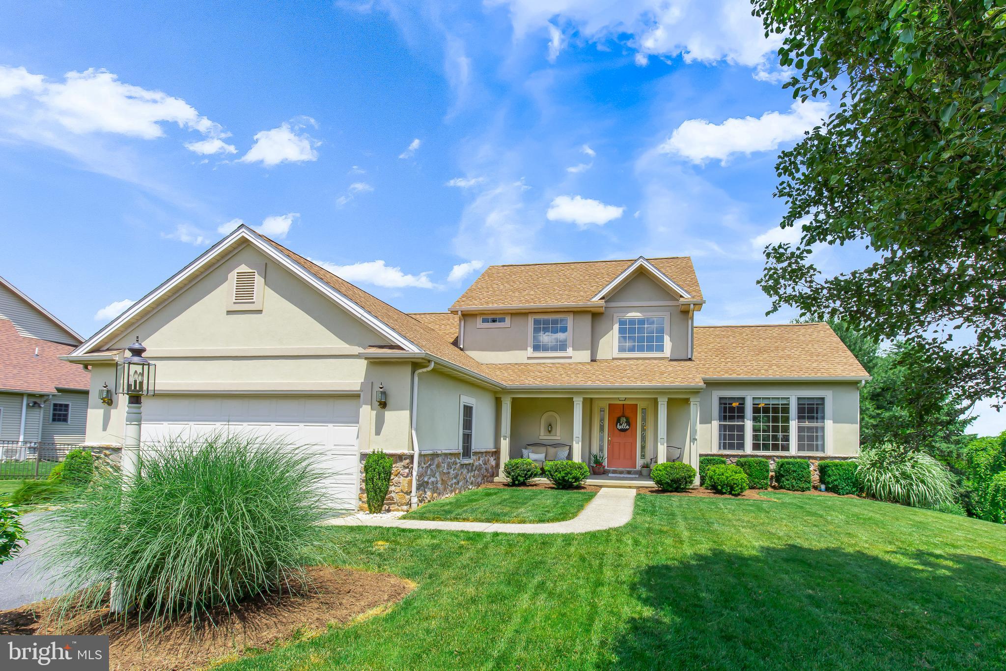 a front view of a house with yard and green space