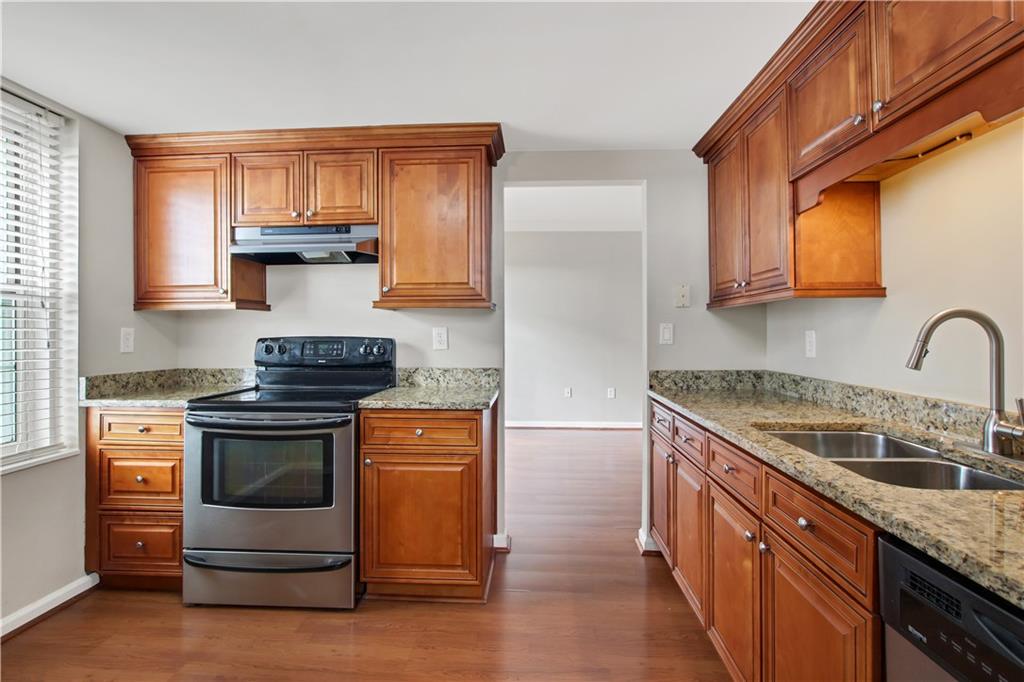 a kitchen with stainless steel appliances granite countertop a stove a sink and a microwave