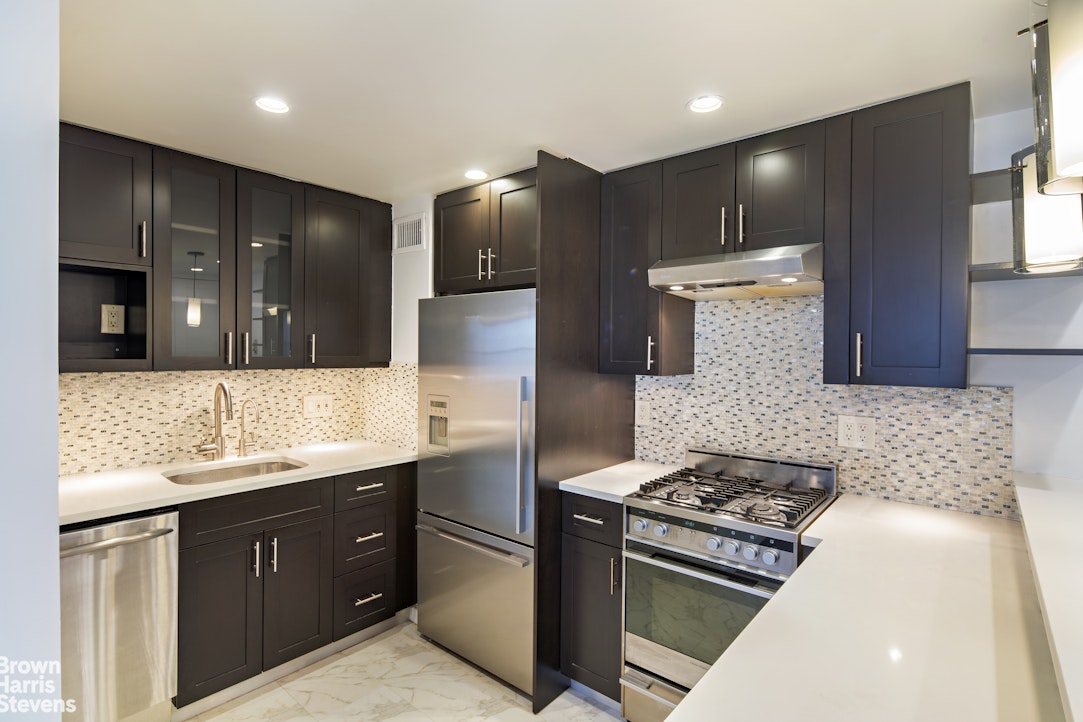 a kitchen with stainless steel appliances a sink stove and cabinets