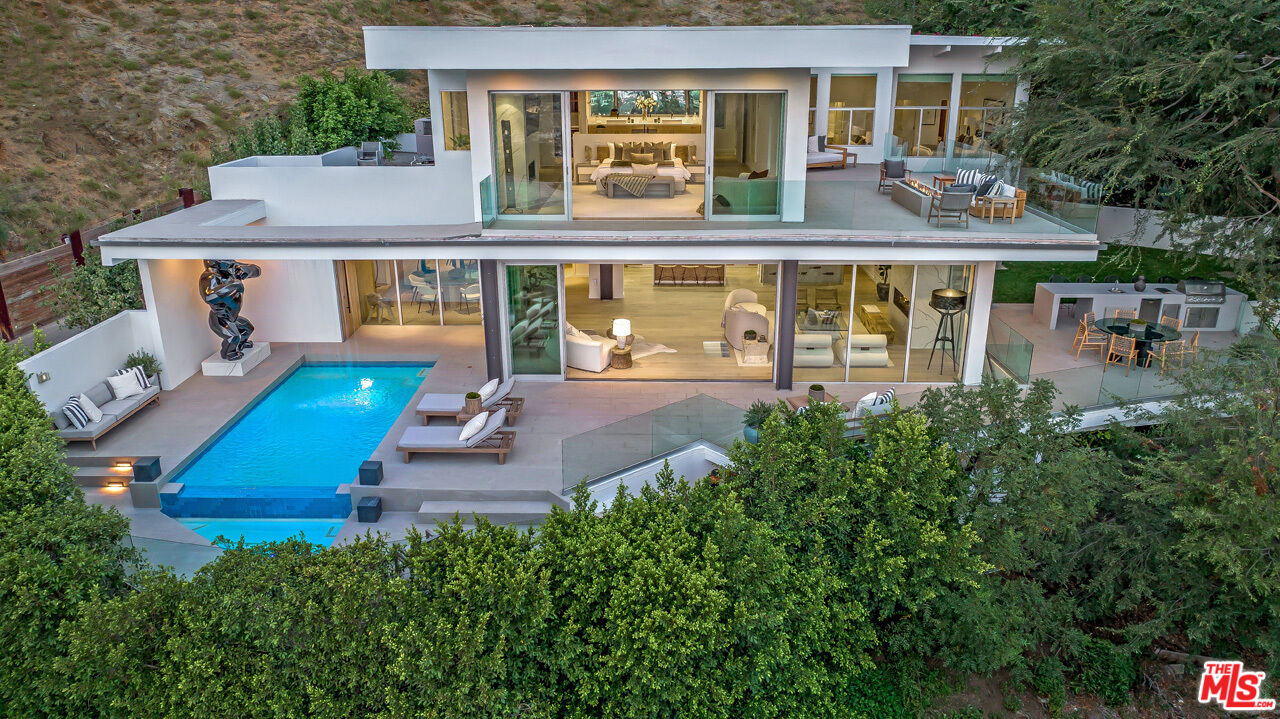 aerial view of a house with a yard balcony and seating area