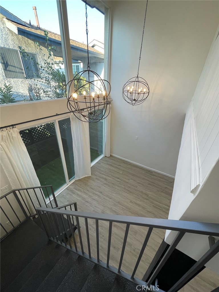 a view of a hallway with wooden floor and glass door