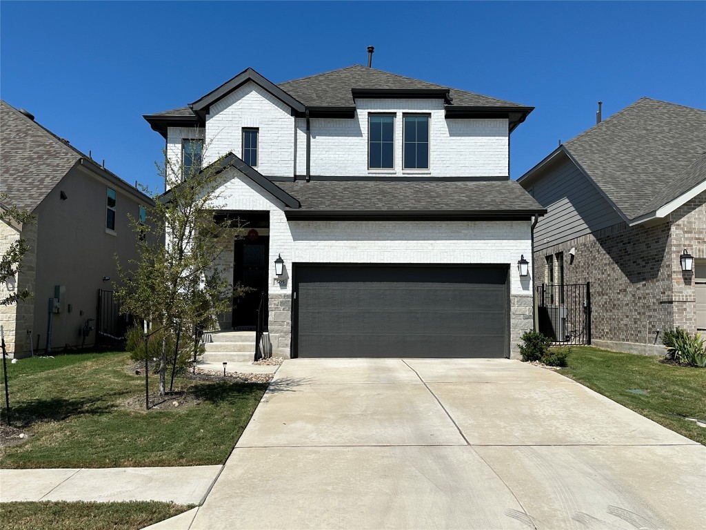 a front view of a house with a yard and garage