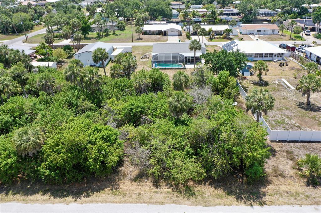 an aerial view of residential houses with outdoor space and trees