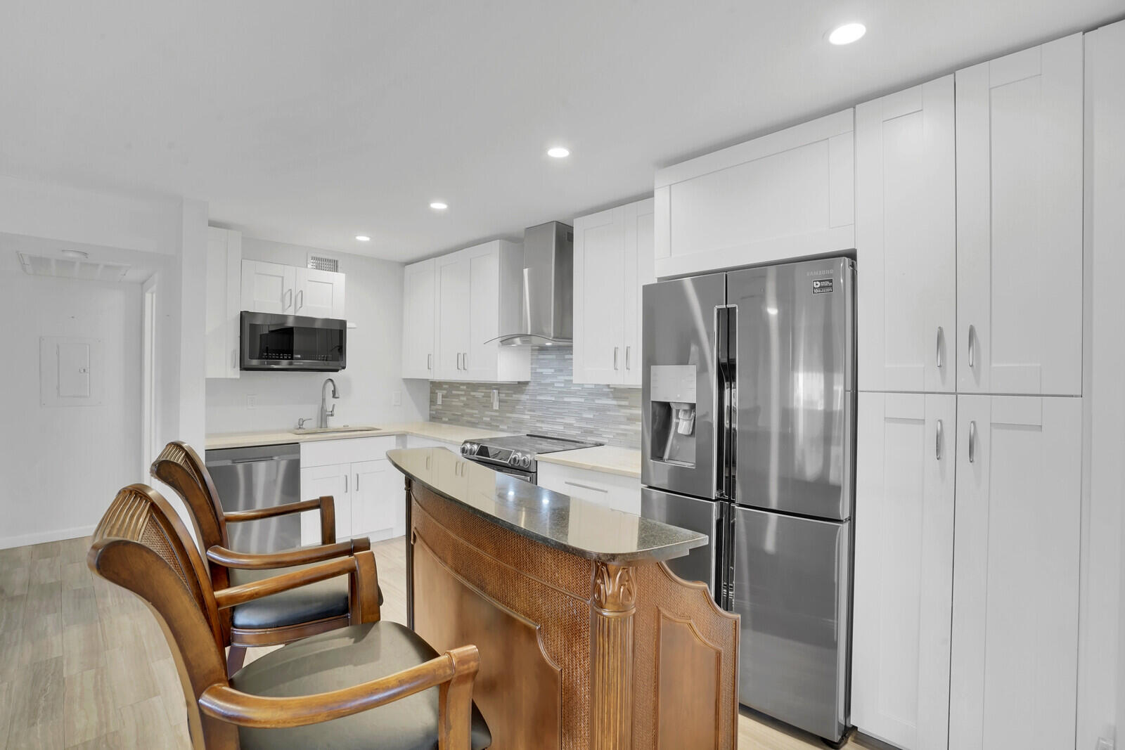 a kitchen with stainless steel appliances granite countertop a refrigerator stove and a sink