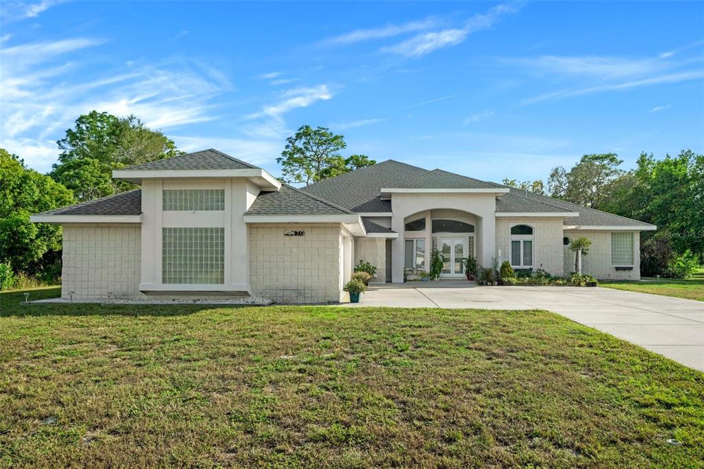 a front view of a house with yard and trees