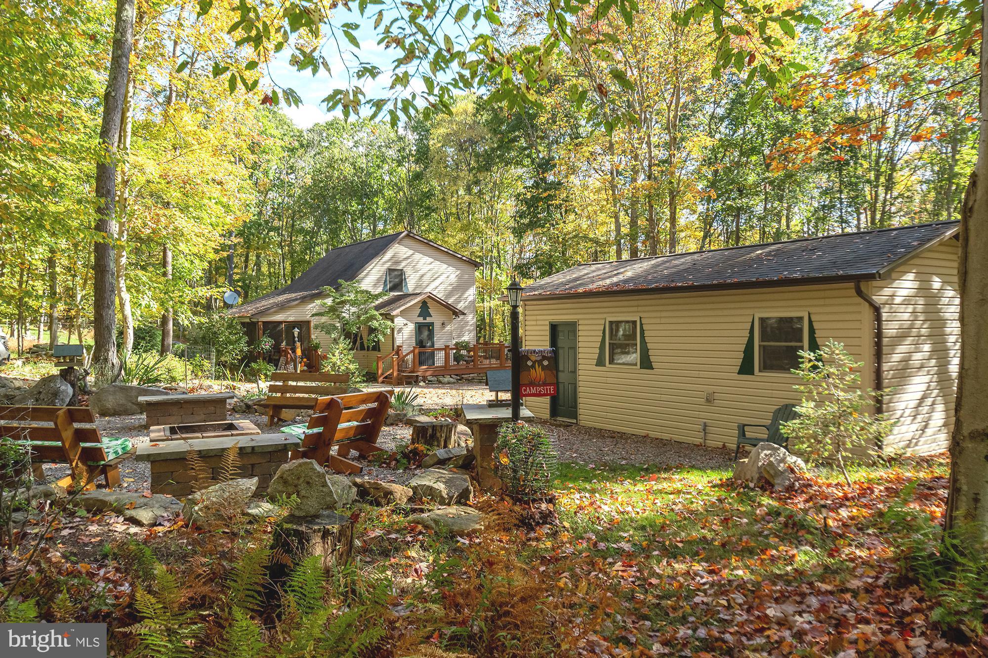 a view of backyard of house with wooden deck and seating space