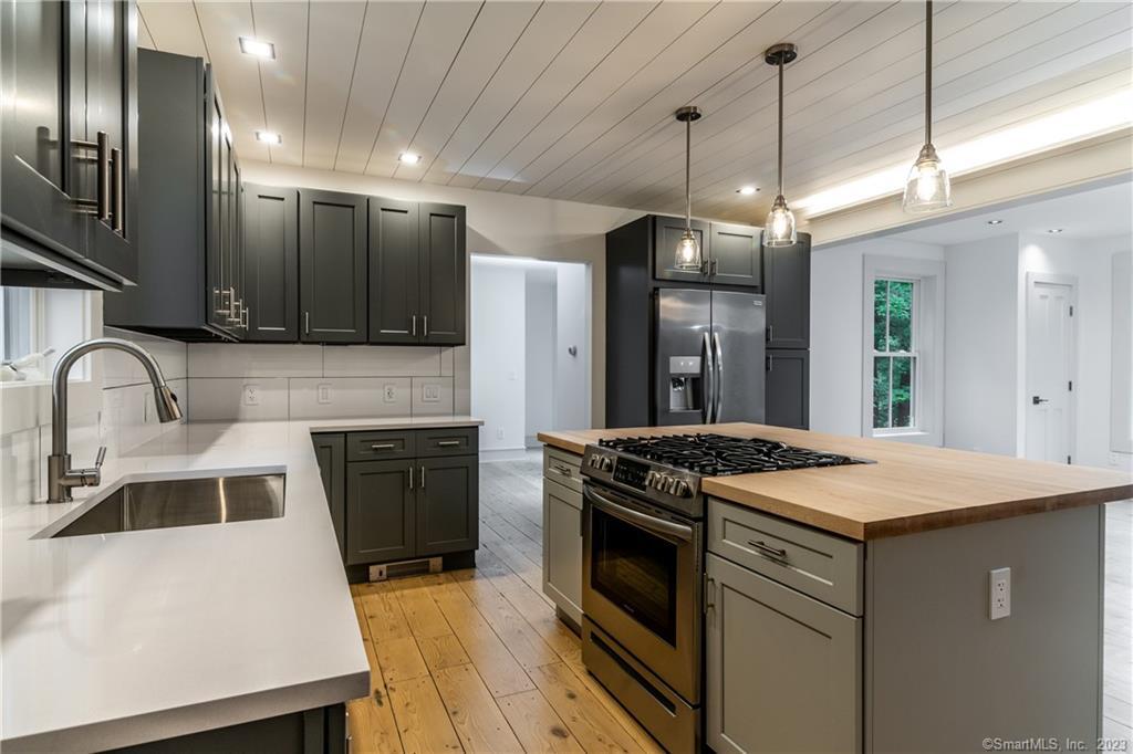 a kitchen that has a stove a sink and a refrigerator