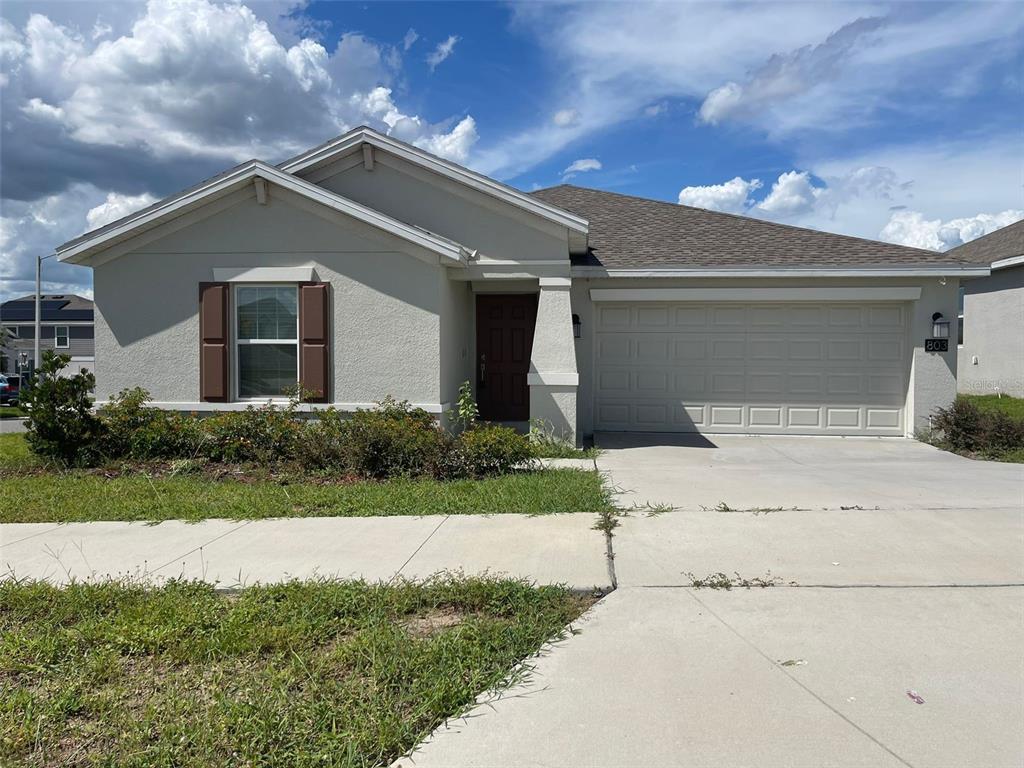 a front view of a house with a yard and garage