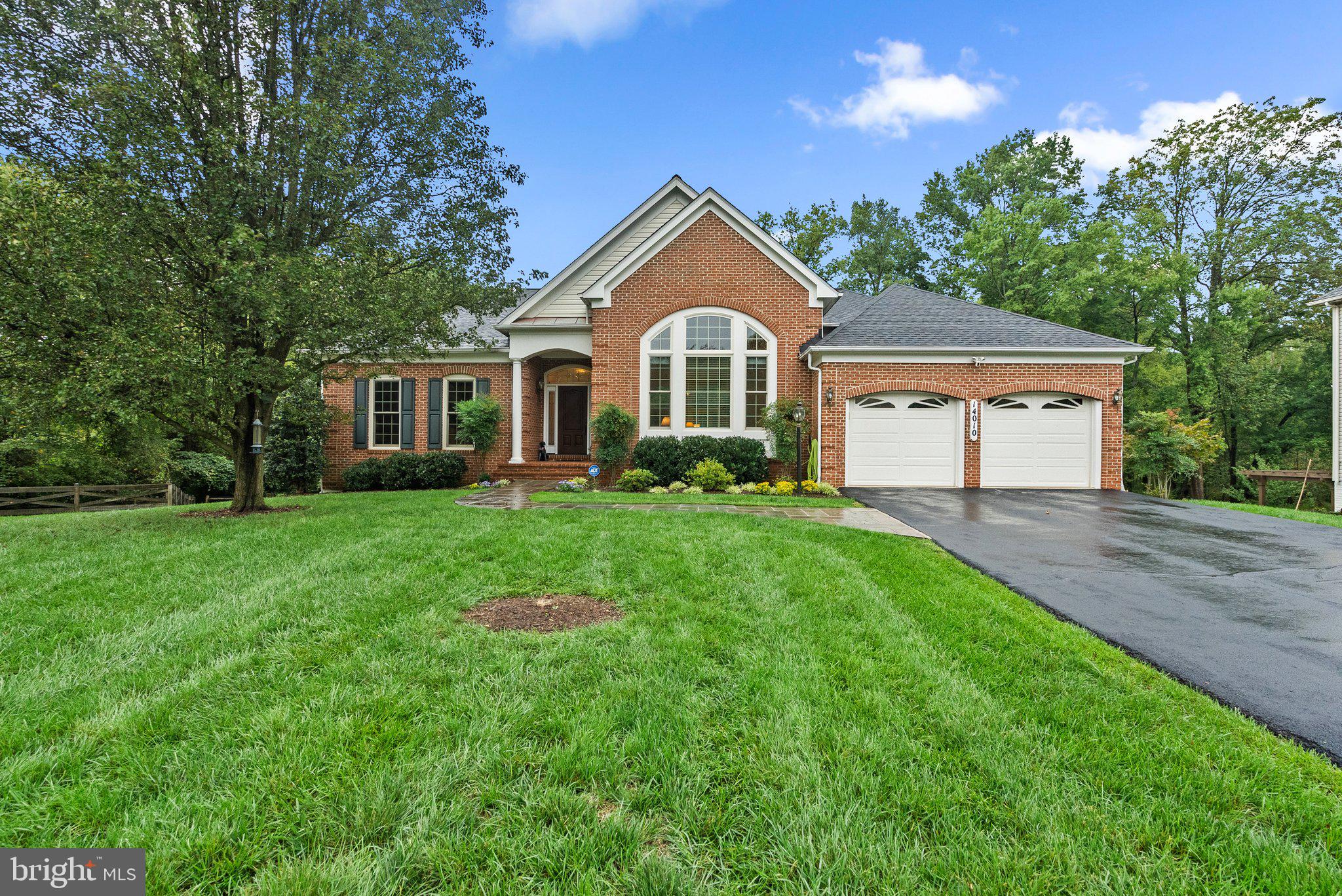 a front view of a house with a yard and trees