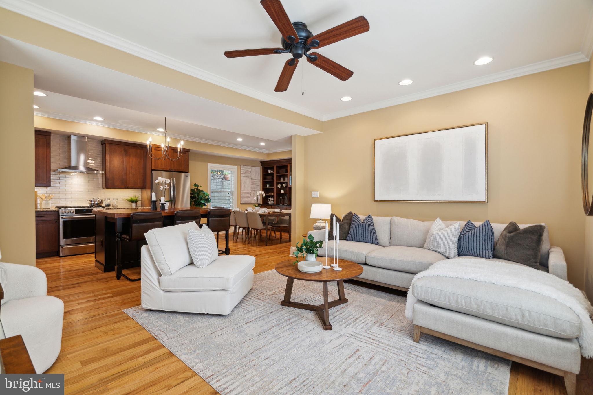 a living room with furniture kitchen view and a large window