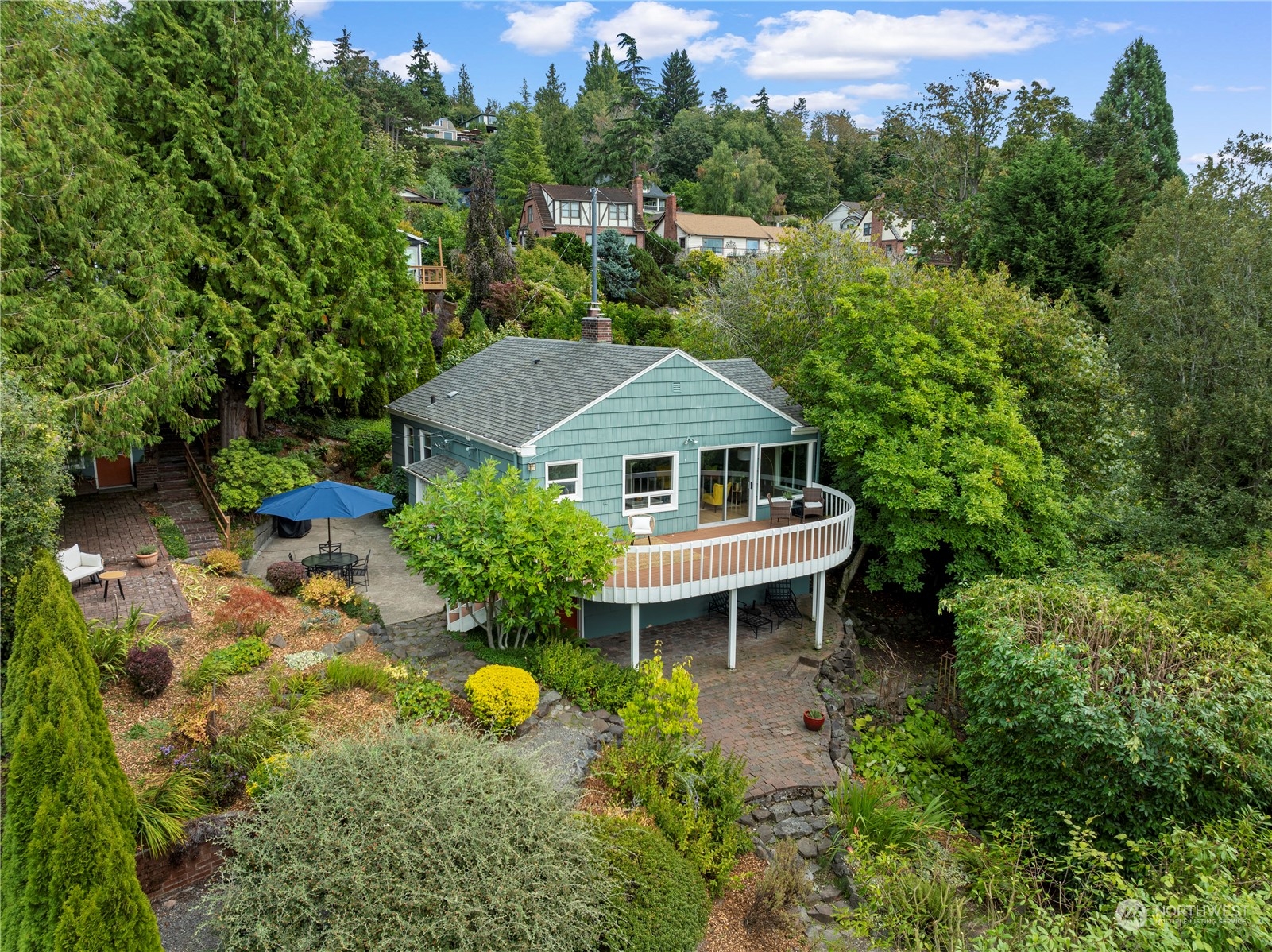 an aerial view of a house with table and chairs under an umbrella