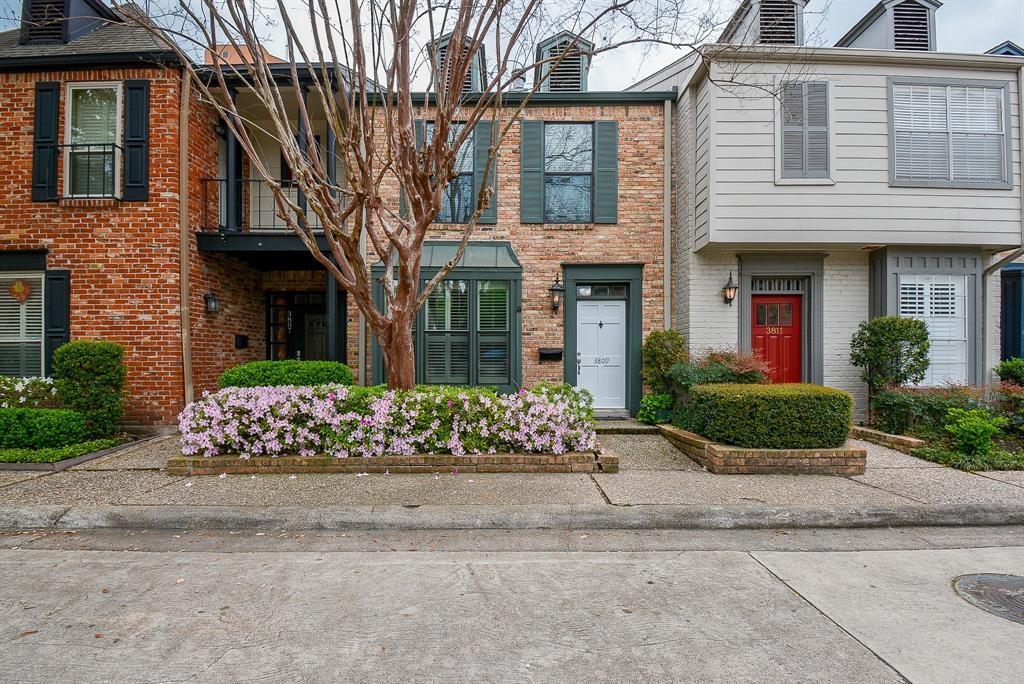 a front view of a house with lots of flowers around