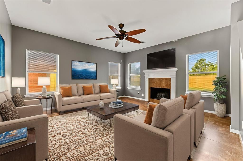 a living room with furniture a fireplace and a flat screen tv