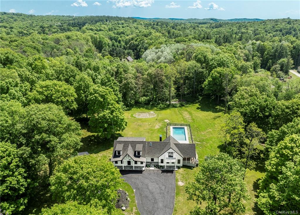 an aerial view of a house with a yard basket ball court and outdoor seating