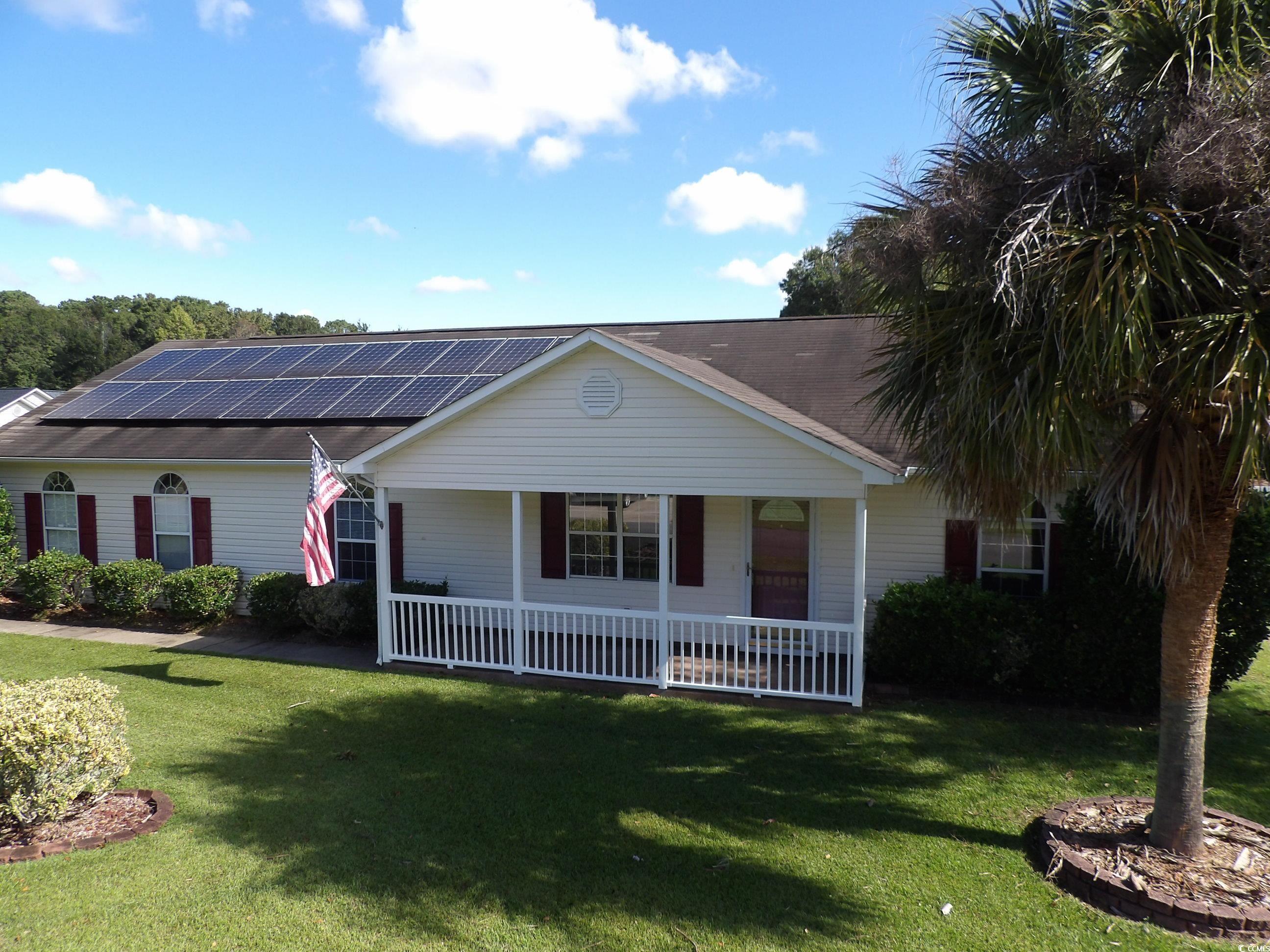 Ranch-style house with solar panels, a front lawn,